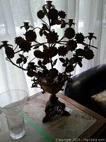 Full view of the gilded metal candelabra showing nine candle holders and floral branches.