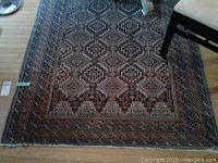 Top-down oblique view of rug under dining chairs showing full pattern and wear