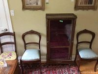 Two antique chairs side by side, one with needlepoint seat and one with brocade seat, showing wood detail and upholstery colors