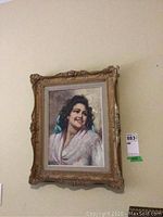 Full view of the oil on board portrait painting titled 'Maria' by E. Frattini in an ornate gilt frame hung on wall.