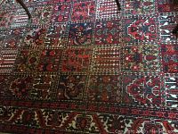Full view of rug on hardwood floor showing grid panel pattern and color palette