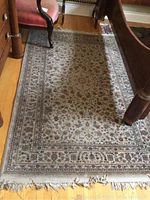 Full view of the Egyptian area rug showing floral pattern, color tones, and fringe detail.