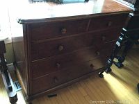 Front view of the full antique dresser with five drawers, showing overall structure and wood finish.