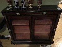 Full front view of cabinet showing two glass doors, ormolu mounts and porcelain plaques
