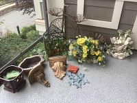 Front view of lot items including planters, metal bicycle plant stand, artificial flowers, and small decorative pieces.