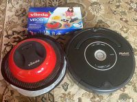 Both units side by side on carpet with Vileda box behind sweeper.