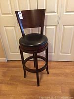 Full view of wooden swivel bar stool showing overall structure and backrest