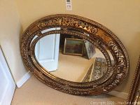 Full view of the oval mirror with ornate design and frame size approximately 43x34