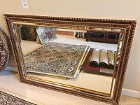 Full front view of the mirror showing overall size, shape, and reflection of carpet and room