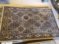 Top view of a rectangular oriental-style area rug with beige, brown, and ivory floral and geometric designs.