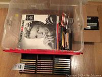 LP records including David Bowie's "ChangesOneBowie" on top, stacked with music CDs and cassette tapes in plastic bins and cases.