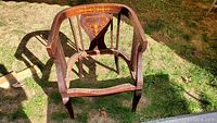 Front view of the wooden chair frame showing Sheraton style inlay on backrest and overall structure including legs and armrests.