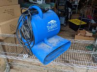 Side angled view showing overall shape, power cord wrapped around handle, and rectangular air outlet.