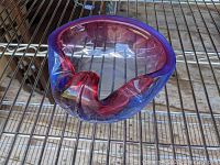 Top and side view of mid-century art glass bowl with purple and pink swirled rim on metal rack