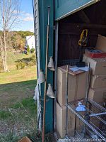 Full view of the tension pole lamp leaning against a wall with three white cone-shaped shades and brass accents