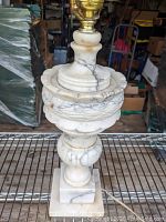 Side view showing the urn-shaped alabaster body with veining and square base.