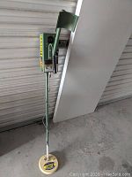 Full view of Garrett ADS II metal detector showing yellow coil and green armrest with grip.