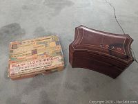 Box labeled 'Frank Lloyd Wright Playing Cards The Museum of Modern Art New York' with a brown leather playing card case beside it.