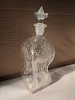 Full view of the antique etched decanter showing its shape and stopper
