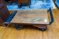 Front view showing wood plank top, cast iron frame and wheel beneath