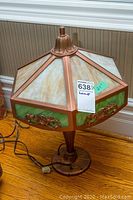 Full view of antique slag glass table lamp showing octagonal shade with frosted textured glass panels and green slag glass sections framed in metal with floral metal accents.