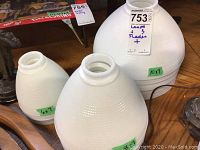 Three milk glass lamp shades of different sizes labeled 6x7, 8x7, and 10x7 inches showing textured white glass design.