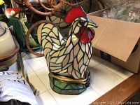 Front view of chicken-shaped stained glass lamp displaying multicolor mosaic.