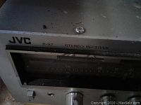 Front upper view of JVC R-S7 Stereo Receiver showing part of the tuning dial and JVC branding.