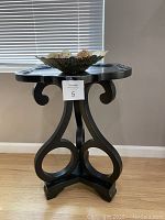 Side view of the black decorative side table with gold decorative bowl on top