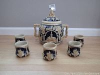 Front view of the full punch bowl set with lid and cups arranged in front, showing design and scale