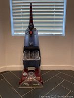 Full front view of the upright carpet cleaner showing general structure, water tank, and handle.