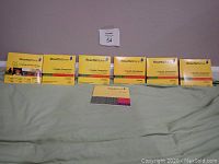 Full set of Rosetta Stone Spanish language learning software for Levels 1 to 5, including Audio Companion supplements, displayed on a green surface against a wall.