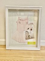 Front view of Studio Decor shadow box in white frame, visibly brand new in packaging showing ballet dress and slippers insert image.