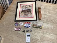 Overview of the train collectibles including framed advertisement, road signs, patches, pinbacks, whistle, and cake toppers on a table