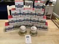 Stack of 17 BallQube baseball display cubes in original boxes, arranged on a table.