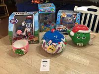 Overview of all six M&M candy dispensers and collectible containers, showing boxed dispensers and ceramic pieces.