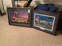 Both framed art prints leaning against couch, showing overall size, framing and matting style