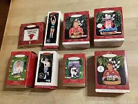 Overview photo showing all eight Hallmark sports ornaments in original boxes on wood surface