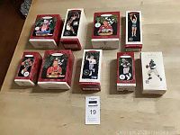Photo of nine Hallmark Keepsake sports ornaments in their boxes arranged on a table.