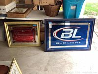 Two framed game room mirrors side by side on concrete floor, showing slight wear on frames.