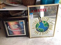 Photo showing both Amstel Light and Bud Light bar mirrors together on floor.