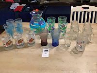 Full assortment laid out on table showing all 20 pieces including pitcher, jars, and various glasses