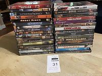 Photo showing stacked DVD cases of various movies in original cases.