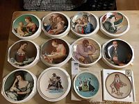 12 collector plates in original styrofoam cases, viewed from above showing various portrait and scene designs.