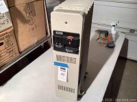 Front angled view of beige metal Delonghi portable space heater showing size and general condition.