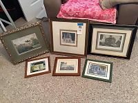 Shows 6 framed and matted wall art prints arranged on the floor including various sizes and frame styles with wear visible