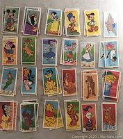 Multiple stacks of colorful vintage Disney collectible cards showing various characters arranged in rows.