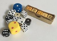 Collection of 12 assorted dice alongside a set of nine amber dice in original box
