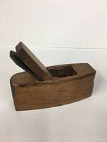 Side view of small wooden hand plane showing blade and wood body.