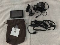 Garmin Nuvi 765 GPS device with windshield mount, soft pouch, and charging cables laid out.